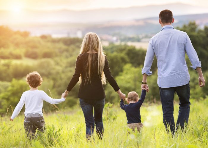 Happy young family spending time together outside in green nature.